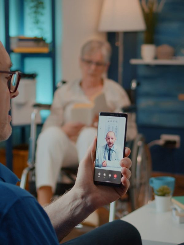 Elder adult using video call to talk to doctor about treatment at home. Senior man talking to specialist about health care on remote teleconference for telehealth and telemedicine.