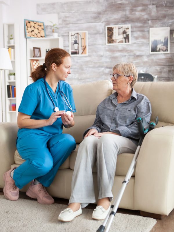 female-nurse-sitting-on-couch-with-senior-woman.jpg