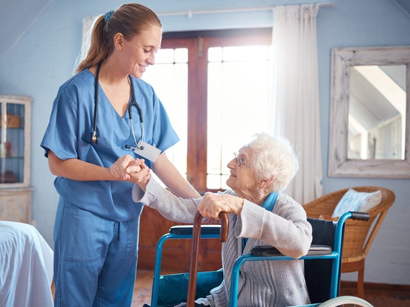 senior-woman-wheelchair-nurse-holding-hands-disability-support-nursing-home-elderly-lady-doctor-consulting-help-advice-physiotherapy-elderly-care-clinic-smile-job-min